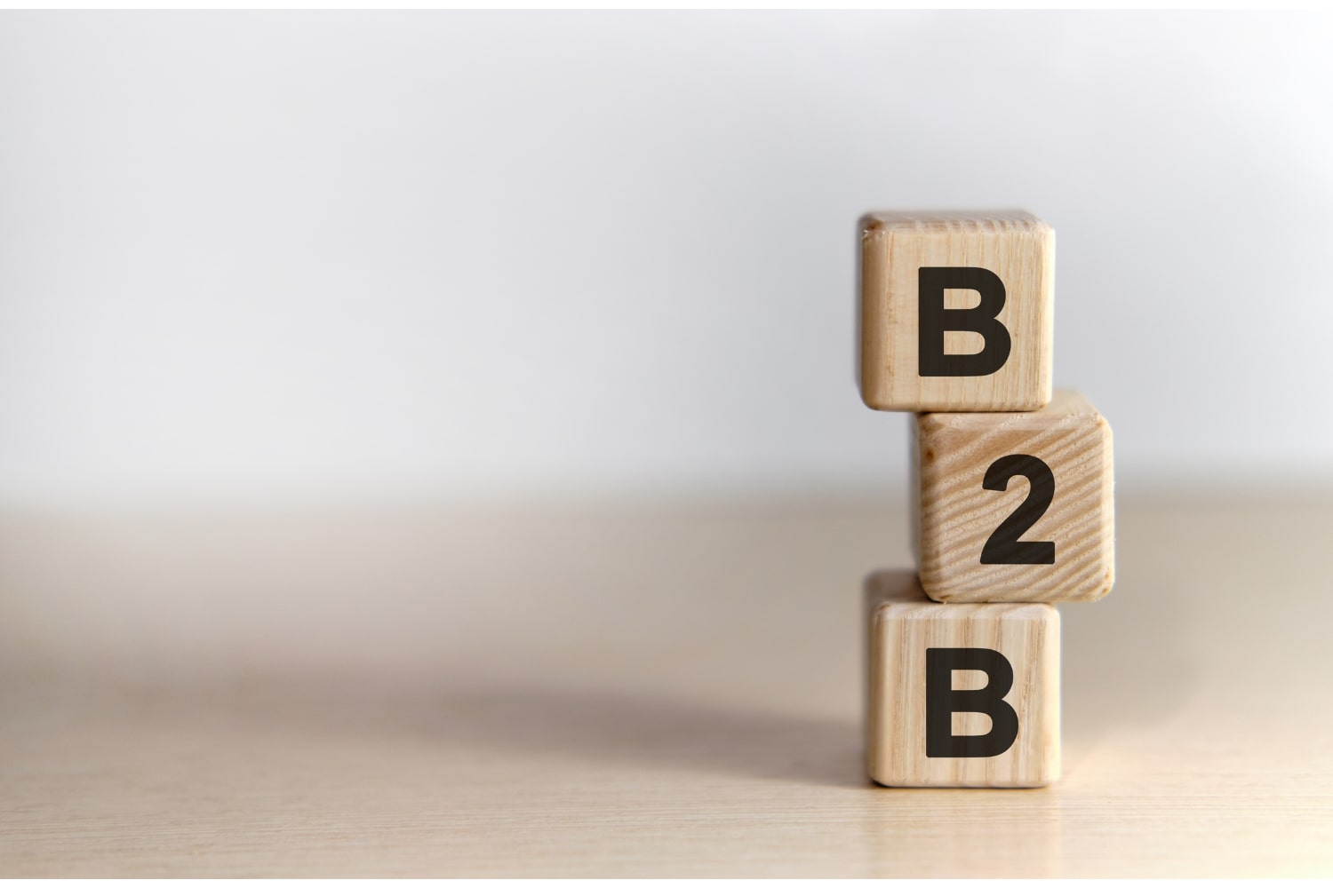 3 Holzwürfel mit der Aufschrift B2B auf einem Tisch
